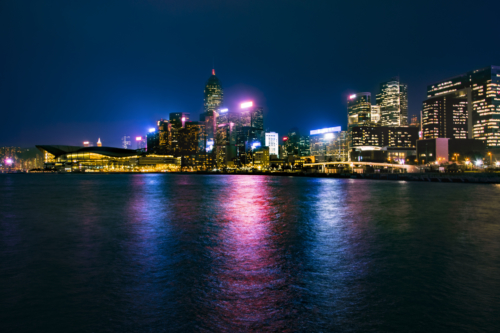 Hong Kong city by night skyscrapers, water reflection, blue sky, Artur Rydzewski photography