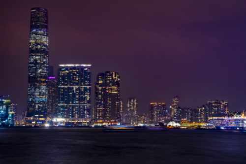 Hong Kong city by night skyscrapers, water reflection, purple sky, Artur Rydzewski photography